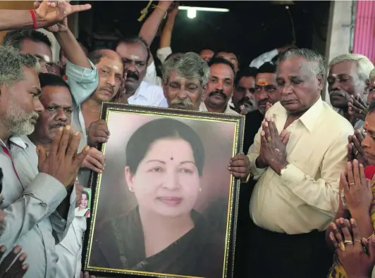  ?? Indranil Mukherjee / AFP ?? Supporters hold a photograph of Tamil Nadu chief minister Jayalalith­aa Jayaram as they offer prayers for her at a temple in Mumbai yesterday.