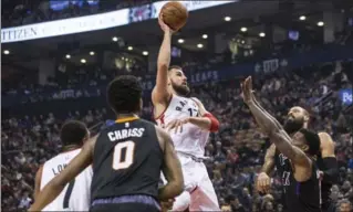  ?? CHRIS YOUNG, THE CANADIAN PRESS ?? Toronto Raptors’ Jonas Valanciuna­s lifts a shot over Phoenix Suns’ Eric Bledsoe and Tyson Chandler in 115-103 loss.