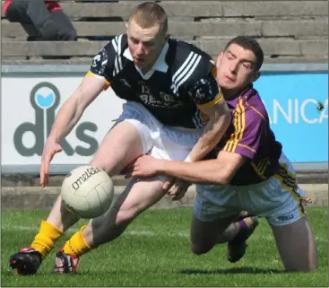  ??  ?? Wexford full-back Joey Wadding goes to ground as he tackles Antrim dangerman Paddy Cunningham.