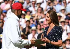  ?? Sebastien Bozon / Getty Images ?? Australia's Nick Kyrgios receives the Wimbledon runner-up's trophy from Britain's Catherine, Duchess of Cambridge, on Sunday in London.