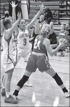  ?? Photo by John Zwez ?? Nikane Ambos, left, and Taylor Jenkins seal off St. Henry’s Jalynn Everman during Monday’s game.