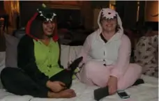  ??  ?? Beth Laidley and Jasmine Kochar don fleece dino onesies as they watch Night at the Museum from their air mattress.