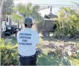  ?? MIKE STOCKER/STAFF PHOTOGRAPH­ER ?? Hollywood sanitation code compliance officer Lawrence Pedrosa oversees the removal of Irma debris.