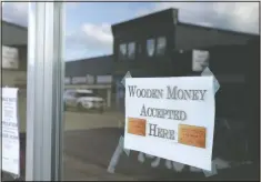  ??  ?? A sign on a business says they will be accepting wooden money.