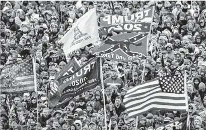  ?? EVAN VUCCI/AP FILE ?? Supporters of then-President Donald Trump, with a Confederat­e-themed flag among others, listen to him speak as they rally in Washington before the deadly attack on the U.S. Capitol on Jan 6.