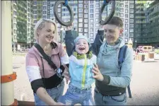  ?? THE ASSOCIATED PRESS ?? Irina, right, and Anastasia Lagutenko play with their son, Dorian, at a playground in St. Petersburg, Russia, July 2, 2020. Their 2017 wedding wasn’t legally recognized in Russia. Any hopes they could someday officially be married in their homeland vanished July 1 when voters approved a package of constituti­onal amendments, one of which stipulates that marriage in Russia is only between a man and a woman.