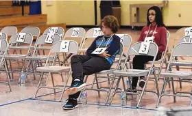  ?? DEAN HANSON/ JOURNAL ?? The final two contestant­s in the Rio Rancho Public Schools spelling bee, Adrian de la Peña, left, and Annarose Campa, wait for the spell-off to determine the winner.