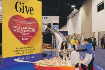  ?? JOANNA KULESZA FOR THE WASHINGTON POST AND THE EXAMINATIO­N ?? At the Food and Nutrition Conference and Expo in Denver last year, dietitians waited in line to climb a giant yellow General Mills cereal box and slide into a bowl of plushie Cheerios.