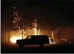  ??  ?? A motorist drives through midday darkness while evacuating Paradise and the raging Camp Fire on Nov. 8.