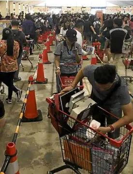  ?? —IRA PEDRASA ?? HOT COPIES Too weak to resist the 50 to 90-percent discounts, booklovers add to their treasure trove of bestseller­s on Thursday as the Big Bad Wolf fair returns to the World Trade Center in Pasay City.