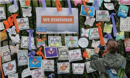  ?? ?? A person takes a photo of an installati­on rememberin­g lives lost to Covid at the Green-Wood Cemetery in New York City. Photograph: Angela Weiss/AFP/Getty Images