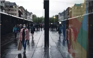  ?? OLI SCARFF AFP/GETTY IMAGES ?? A woman wearing a mask walks down a street in Manchester, England, on Friday. Britain has Europe’s highest pandemic death toll, with more than 42,000 virus-related fatalities.