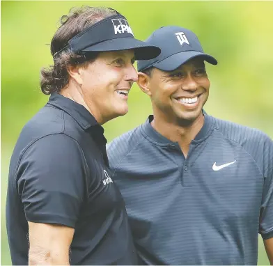  ?? SAM GREENWOOD / GETTY IMAGES FILES ?? Golf fans will remember the original 2018 TV match between Phil Mickelson and Tiger Woods. On Sunday in Florida, the golf legends will pair up with two football legends in a golf match for charity.