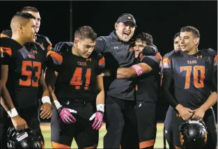  ?? Morgan Timms ?? Taos senior Estevan Valerio embraces Coach Art Abreu Jr. Friday (Oct. 26) after Taos’ 50-0 victory over Pojoaque Valley at Anaya Stadium in Taos. All of the seniors and their parents were honored before and after the game, which was shortened due to the mercy rule.