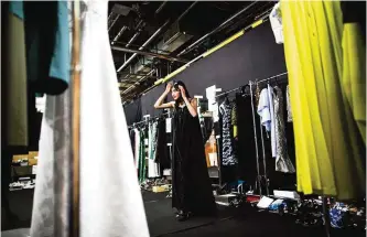  ??  ?? Japanese model Rina Fukushi checks her dress in the mirror in back stage of a show by Japanese designer Tae Ashida during the Tae Ashida 2017 Spring/Summer collection show in Tokyo.