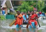  ?? ERANGA JAYAWARDEN­A — THE ASSOCIATED PRESS ?? Sri Lankan Buddhist monks and villagers travel in a makeshift raft in a flooded area at Wehangalla village in Kalutara district, Sri Lanka, Saturday. Sri Lanka has appealed for outside help as dozens were killed in floods and mudslides and dozens others went missing.