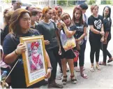  ?? — AP ?? PHUKET: Chiranut Trairat, (second from left) mother of an 11-month-old baby girl, stands next to her daughter’s portrait before her funeral in Phuket, Thailand yesterday. Her distraught husband hanged their daughter on social media website Facebook...