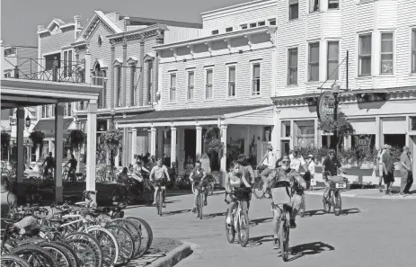  ?? ERIC SEALS/DFP ?? Vacationer­s walk in downtown Mackinac Island. Data shows many Michigande­rs traveled away from home over the holiday.