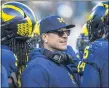  ?? ASSOCIATED PRESS FILE PHOTO ?? Michigan head coach Jim Harbaugh huddles with his players on the field during a time out in a 2019game against Michigan State in Ann Arbor.