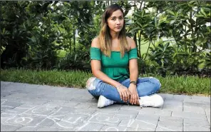  ?? (The New York Times/Eve Edelheit) ?? Valeria Rodriguez, who is from North Coahuila, Mexico, sits last month outside the home where she is an au pair for four children between the ages of 1 and 5 years in Tampa, Fla. Au pairs who came to work in the United States during the pandemic have had a scaled-back experience: personal travel has been considerab­ly curtailed, as has socializin­g with other au pairs and locals, and they are spending much more time with their host families than they anticipate­d.