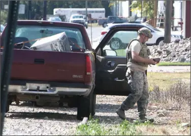  ?? The Sentinel-Record/Richard Rasmussen ?? HANDLE WITH CARE: A member of the 19th Civil Engineer Squadron Explosive Ordnance Disposal team from the Little Rock Air Force Base removes a live World War I-era artillery round from the front seat of a pickup truck in the 200 block of Valley Street...