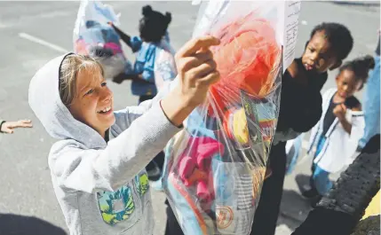  ?? Patti Blake, News Herald ?? Colby Diagle and other students check out bags of donated clothes and school supplies this month in Panama City, Fla. As recently as Monday, schools in the Florida Panhandle were still dealing with sporadic power outages.