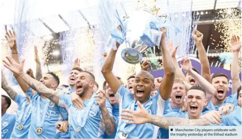  ?? ?? Manchester City players celebrate with the trophy yesterday at the Etihad stadium