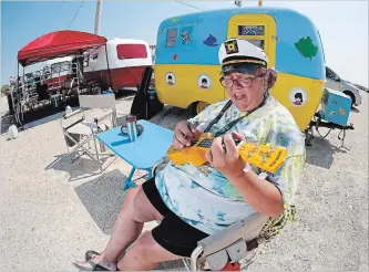  ?? JOHN WOODS THE CANADIAN PRESS ?? Angela Durand plays the ukulele outside her Yellow Submarine-themed trailer at the Boler 50th anniversar­y weekend in Winnipeg.Hundreds of Boler trailers, invented in Winnipeg, from all corners of North America hit the road and made their way to Winnipeg to celebrate the birth of the iconic camper trailer.