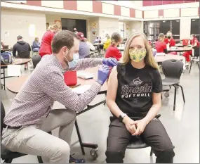  ?? LYNN KUTTER ENTERPRISE-LEADER ?? Jason Engstrom, a fourth-year student with UAMS College of Pharmacy, administer­s the second covid-19 vaccinatio­n for Elzie Fields, Lincoln High School softball coach and a high school English teacher. Lincoln Consolidat­ed School District held its second clinic for school employees on Friday at the high school commons area.