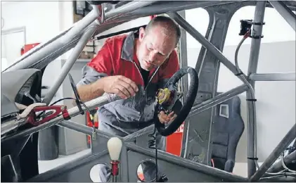  ?? Photos: MAVERICK MOTORSPORT GROUP ?? Work in progress: Baigent Motors manager Justin Scelly puts the steering wheel in his team’s Holden Commodore V8 race car.