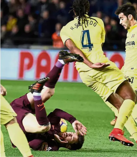  ??  ?? Marked man: Barcelona’s Lionel Messi is fouled in the La Liga match against Villarreal on Sunday. — AFP