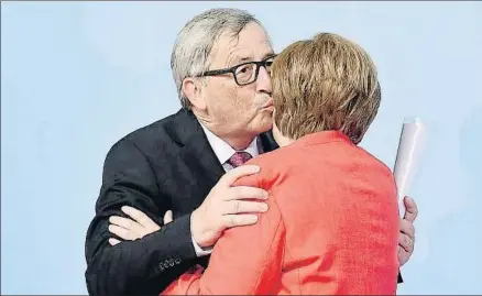  ?? LUKAS BARTH / EFE ?? Jean-Claude Juncker, presidente de la Comisión Europea, besando a Angela Merkel, canciller alemana, ayer