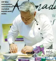  ??  ?? CEF Wan menunjukka­n cara membuat murtabak kepada wakil media.