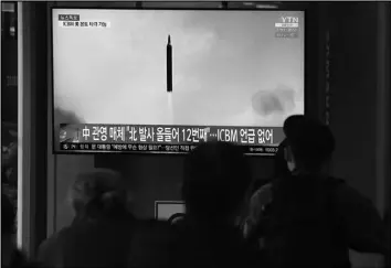  ?? Tribune News Service ?? People watch a TV at the Seoul Railway Station showing a file image of a North Korean missile launch on March 24, 2022, in Seoul, South Korea.