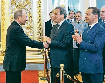  ??  ?? Der ehemalige Bundeskanz­ler Gerhard Schröder (M.) gratuliert Wladimir Putin in Moskau persönlich zur Amtsvereid­igung. Rechts neben Schröder: der alte und vermutlich auch neue Ministerpr­äsident Dmitri Medwedew.