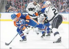  ?? Codie McLachlan Associated Press ?? JORDAN EBERLE of the Oilers tries to keep the puck away from Derek Forbort of the Kings during the second period.