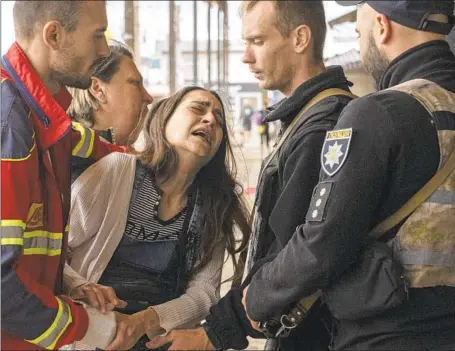  ?? SABINA POGORELETS Evgeniy Maloletka Associated Press ?? cries after her husband, Adam, was killed by Russian shelling of a crowded public bazaar in Kharkiv, Ukraine.