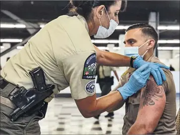  ?? Irfan Khan Los Angeles Times ?? LOS ANGELES COUNTY
Sheriff ’s Deputy Kenneth Anderson is vaccinated March 5 at a department clinic.