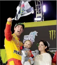  ?? AP/TERRY RENNA ?? Joey Logano waves a checkered flag as he stands with his wife and son after winning Sunday’s NASCAR Cup championsh­ip at the Homestead-Miami Speedway in Homestead, Fla.