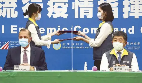  ?? AP ?? US Health and Human Services Secretary Alex Azar (seated left) and Taiwanese Minister of Health and Welfare Chen Shih-chung sign a memorandum of understand­ing during a ceremony at the Central Epidemic Command Center in Taipei yesterday.