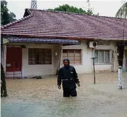  ?? (Foto Muhammad Najmi Nor’azam/bh) ?? Penduduk meredah air banjir di Kampung Mohd Amin, Johor Bahru, semalam.