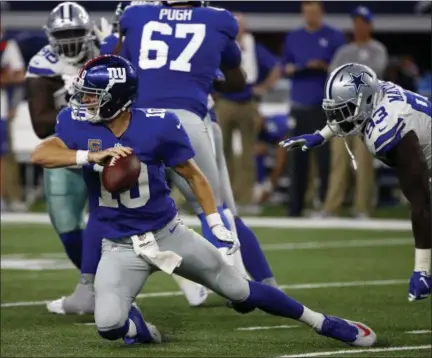  ?? RON JENKINS — THE ASSOCIATED PRESS ?? New York Giants quarterbac­k Eli Manning ( 10) attempts to get rid of the ball under pressure from Dallas Cowboys defensive end Benson Mayowa ( 93) in the second half of an NFL football game, Sunday in Arlington, Texas.