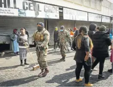  ??  ?? Soldados sudafrican­os patrulland­o en la calle.