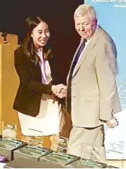  ??  ?? Jazmin Tan Jabines is congratula­ted by head judge Alan Johnson after emerging as grand finals champion in the English Speaking Union’s Internatio­nal Public Speaking Competitio­n in London.