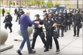  ?? Mike Desmond WBFO ?? A POLICE OFFICER in Buffalo, N.Y., shoves Martin Gugino, 75, who was protesting racial inequality. Gugino fell to the ground and was seriously injured.