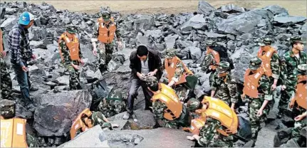  ?? GETTY-AFP ?? Rescuers search through boulders strewn by a landslide in Xinmo village on Saturday.