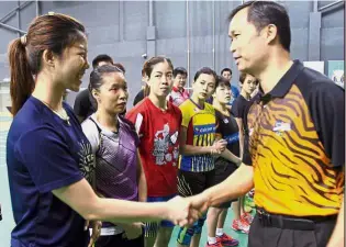  ??  ?? Let’s do it: Commonweal­th Games chef-de-mission Huang Ying How (right) shaking hands with the national shuttlers during a visit last month.