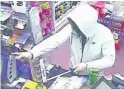  ??  ?? > Masked robber Eric McShane brandished a dagger-like knife at a Happy Shopper store