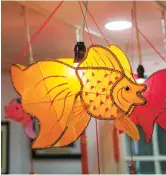  ??  ?? Goldfish swim below the ceiling of He’s studio during Spring Festival.