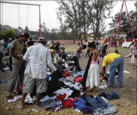  ?? FELIX MARQUEZ / ASSOCIATED PRESS ?? Central American migrants in the Migrant Stations of the Cross caravan go through donated clothing during the caravan’s stop Monday at a sports center in Matías Romero, Mexico. The caravans have been held in southern Mexico for years as an...